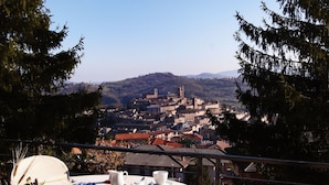 A table set for breakfast with a scenic view of a town in the background. - Hotel Eden Spa (Sarnano)