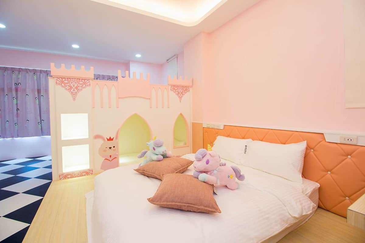 Ein Schlafzimmer mit einem Bett, Kissen und Stofftieren.