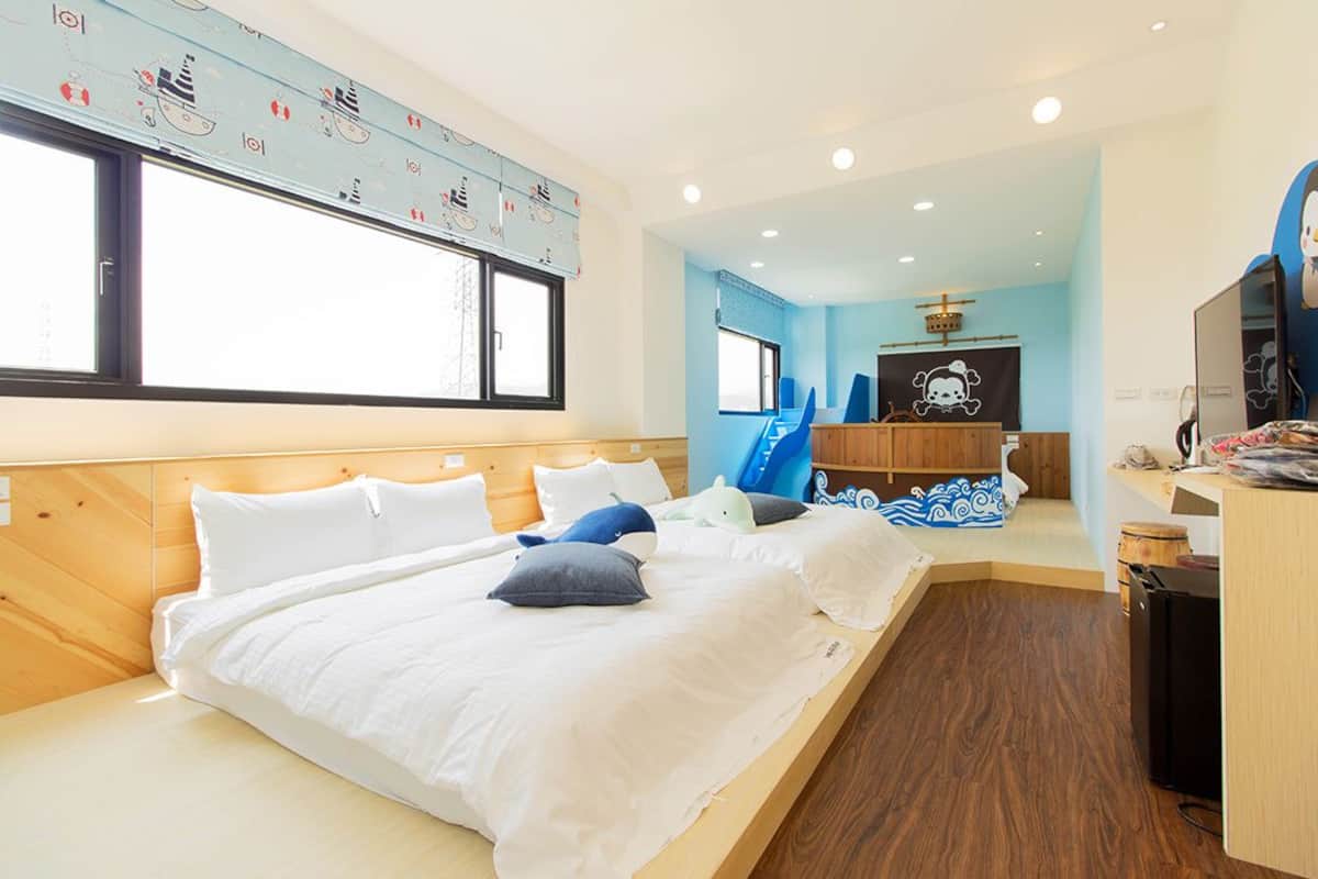 Ein Hotelzimmer mit einem großen Bett, einem Schreibtisch, einem Stuhl und einem Fernseher.
