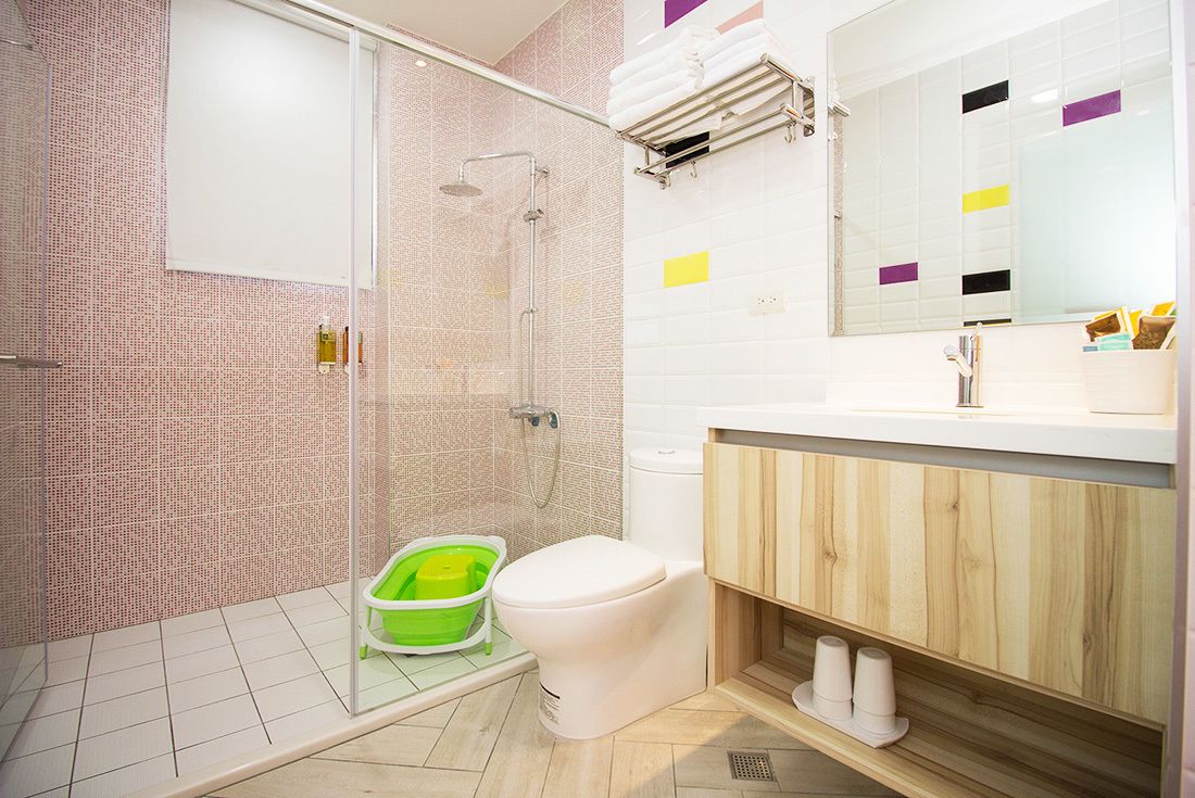 A modern bathroom with a glass shower enclosure, a toilet, and a vanity with a mirror.