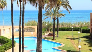 Ein Pool, umgeben von Palmen, mit Blick auf das Meer.