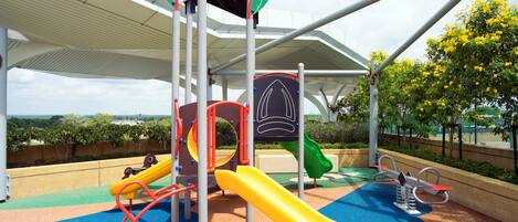 Un parque infantil con toboganes, estructuras para escalar y una zona cubierta.