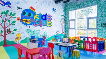 A children's play area with colorful furniture and a mural reading "Kids Club".
