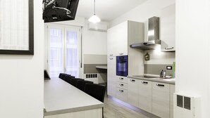 A modern kitchen with a dining area, featuring a large island, built-in oven, and stainless steel appliances. - IN FAIR 8: front fair, front fair elegant and comfortable residence (Bologna)