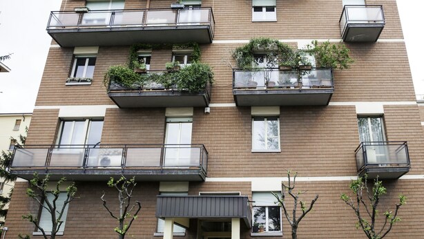 A multi-story residential building with balconies, some with plants, and a gated entrance. - IN FAIR 8: front fair, front fair elegant and comfortable residence (Bologna)