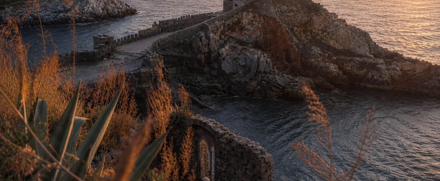 Un paisaje costero con formaciones rocosas y un camino que lleva al mar.