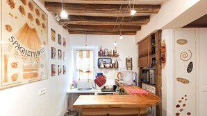 Een keuken met houten balken, een houten kookeiland en diverse keukenapparaten.
