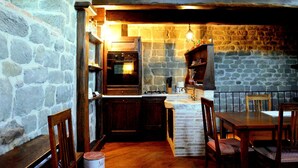 A rustic kitchen with stone walls, wooden furniture, and a built-in oven. - Medieval Tower Lungarno perfect location for inlove (Pratovecchio)
