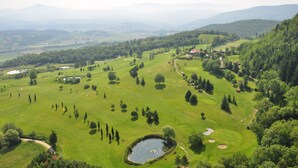 A golf course with a pond, trees, and a distant mountain range. - Medieval Tower Lungarno perfect location for inlove (Pratovecchio)