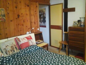 2 dormitorios y tabla de planchar con plancha