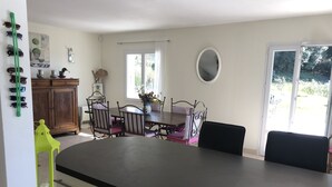 A kitchen with a large island, dining table, and chairs. There is a cabinet, a window, and a mirror on the wall. - Villa 8 people, swimming pool. Open view. Beaches 15 mins away, quiet. (Roquefort-Les-Pins)