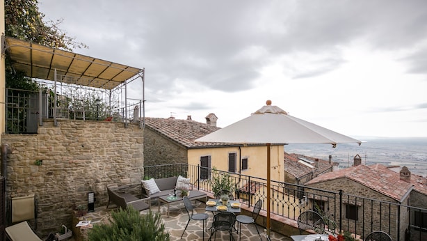 A stone patio with outdoor seating, a covered area, and a view of the sea. - Romantic shelter for 2, amazing view and large equipped terrace (Cortona)
