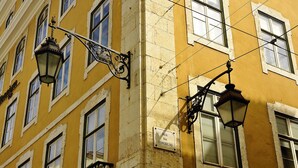 Eine Gebäudefassade mit mehreren Fenstern und Straßenlaternen.