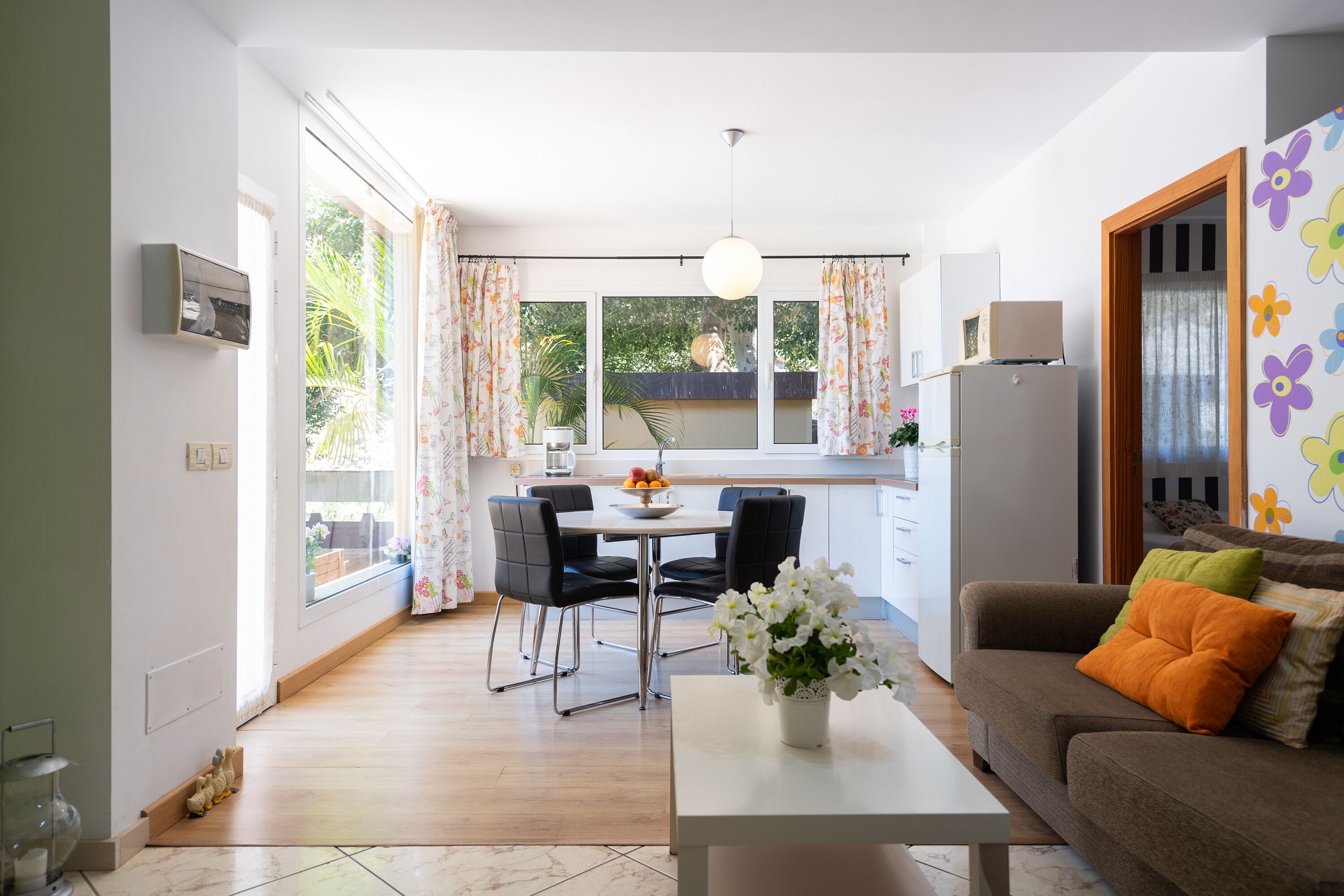 Un salon moderne comprenant un canapé, une table basse et un coin repas avec des chaises.
