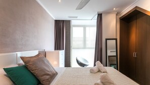 A modern hotel room with a large bed, a headboard, a wardrobe, and a view of the outside. - ApartUP Patacona Terrace Duplex II (Alboraya)