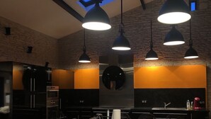 Een moderne keuken met zwarte kastjes, een centraal eiland en hanglampen.