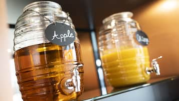 Two glass dispensers with metal taps, one labeled "Apple" and the other "Orange."