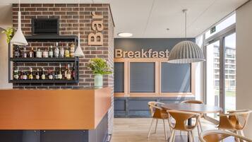 A breakfast bar with a brick wall, shelves of bottles, and a sign that reads "Breakfast".