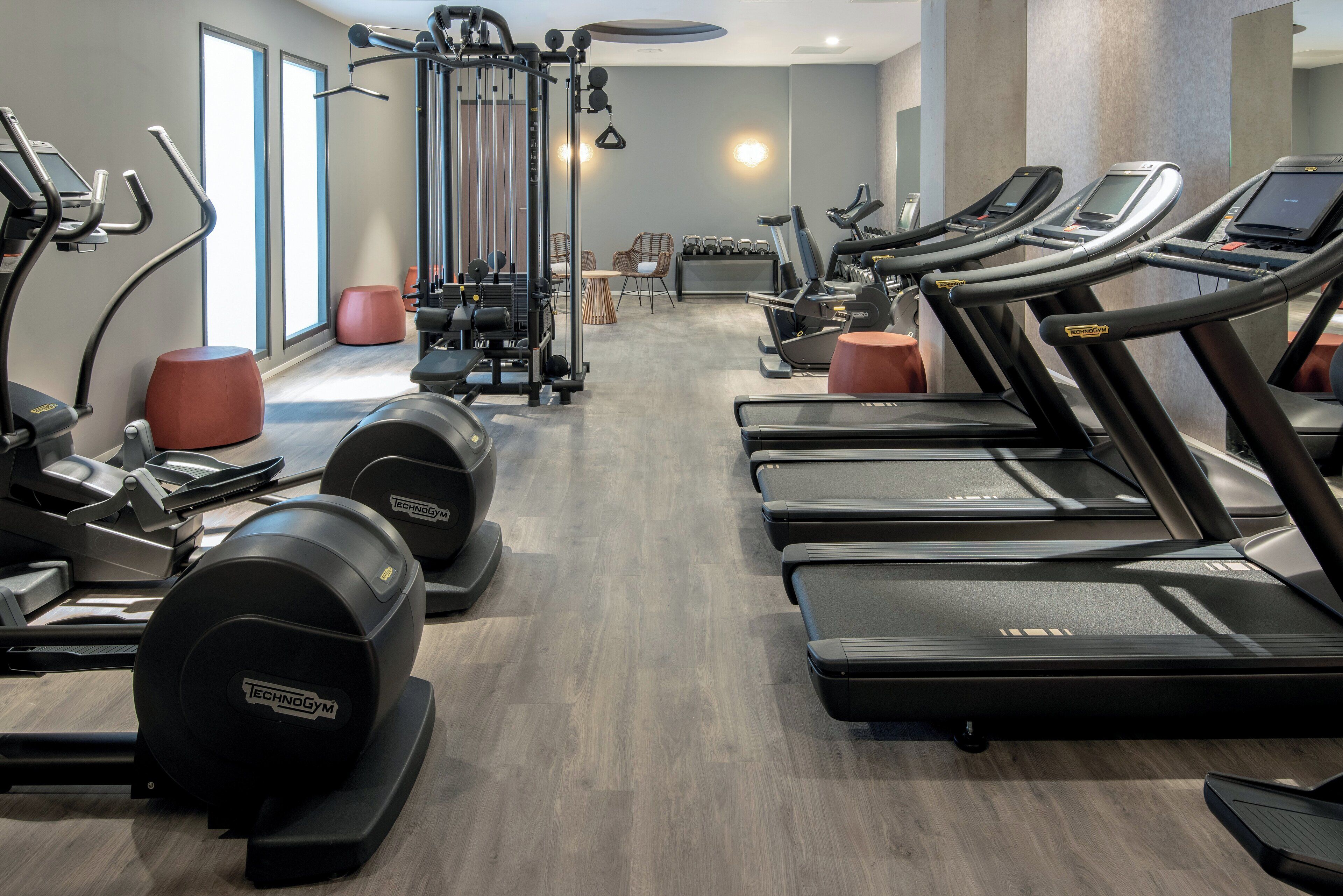 A gym with treadmills, elliptical machines, and weight equipment.