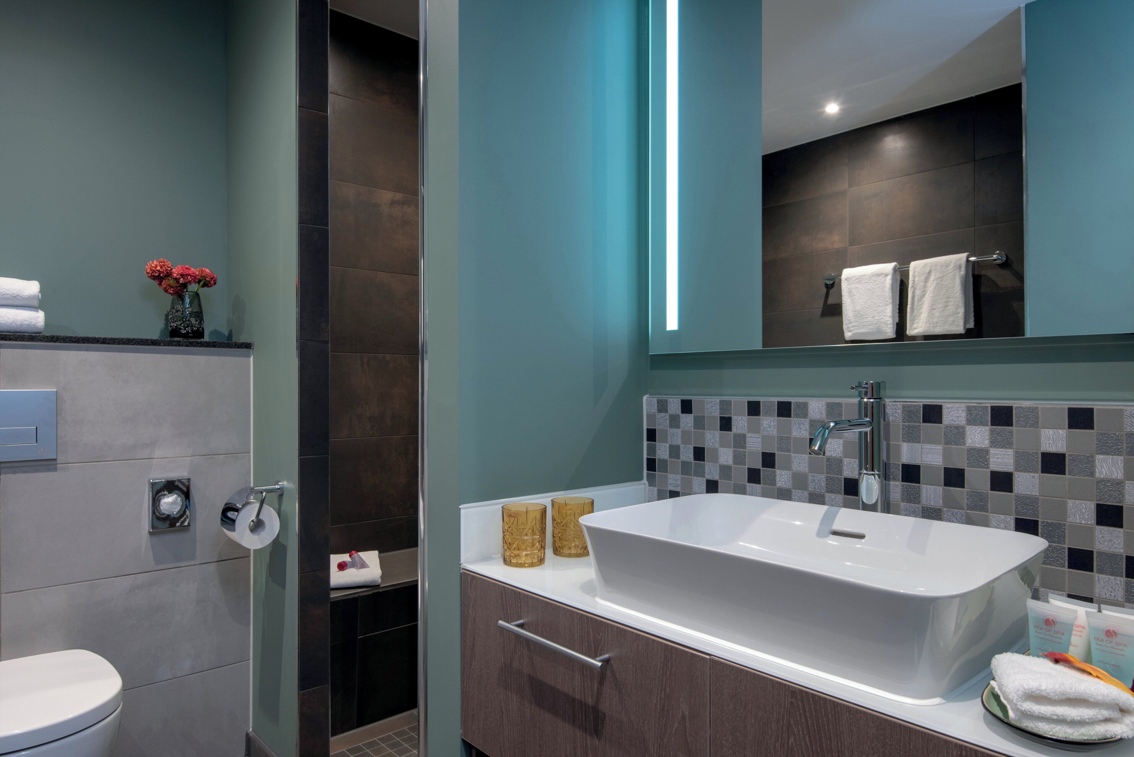 A modern bathroom with a large bathtub, a toilet, and a shower area.