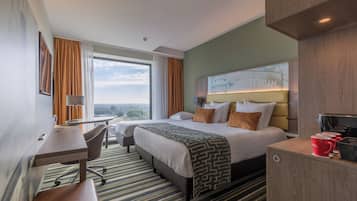 Une chambre d’hôtel avec un grand lit, un bureau, une chaise et une vue sur la ville.