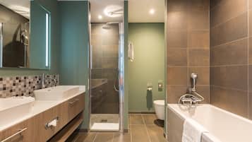 A modern bathroom with a walk-in shower, a bathtub, and a toilet.