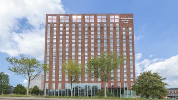 Ein hohes Backsteingebäude mit der Aufschrift 'Leonardo Royal Hotels' oben.