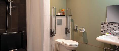 A bathroom with a shower, toilet, and sink.