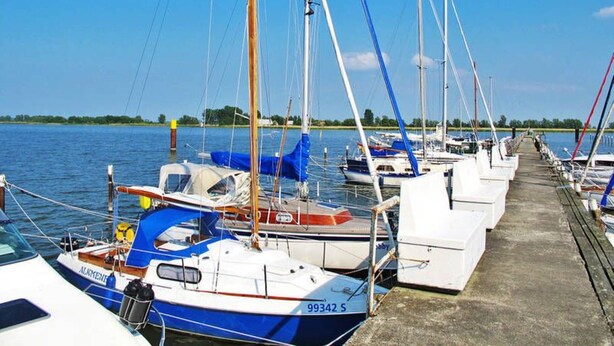 A marina with several boats docked along a concrete pier. - Ferienhaus Netzelkow am Achterwasser, Usedom, Baltic Sea, with WiFi, family-friendly (Lütow OT Netzelkow)