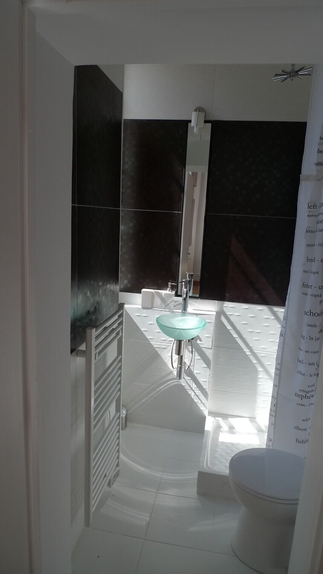 Ein modernes Badezimmer mit einem Glaskonstruktion-Waschbecken, weißen Fliesen und einer Duschkabine.