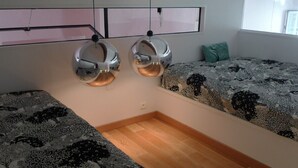 Una habitación con dos literas, piso de madera y colcha estampada.