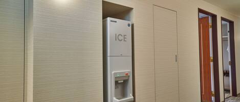A corridor with a water dispenser labeled 'ICE' and a sign indicating the ice room.