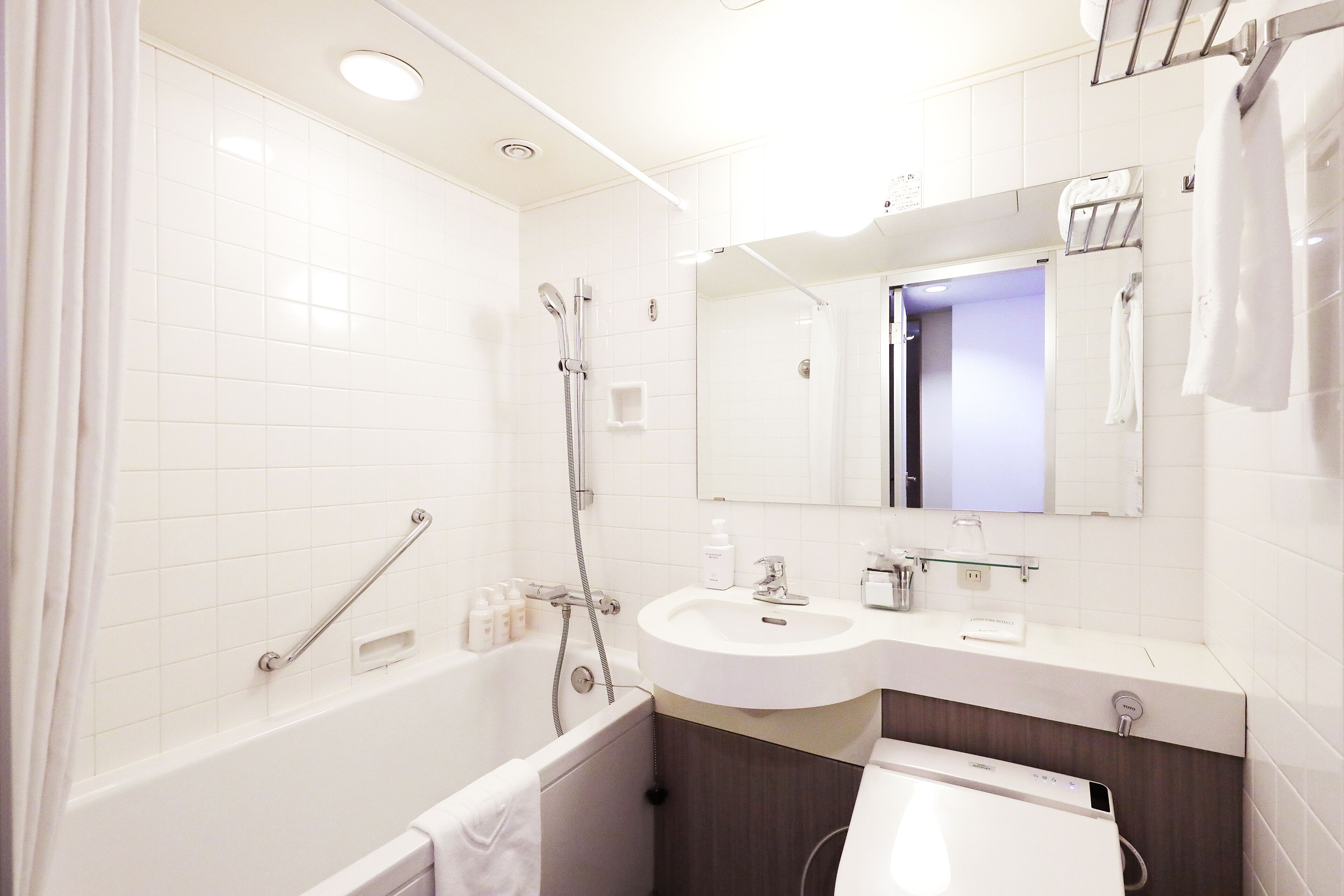 Une salle de bain moderne équipée d’une baignoire, d’une douche, d’un lavabo et d’un meuble-lavabo.