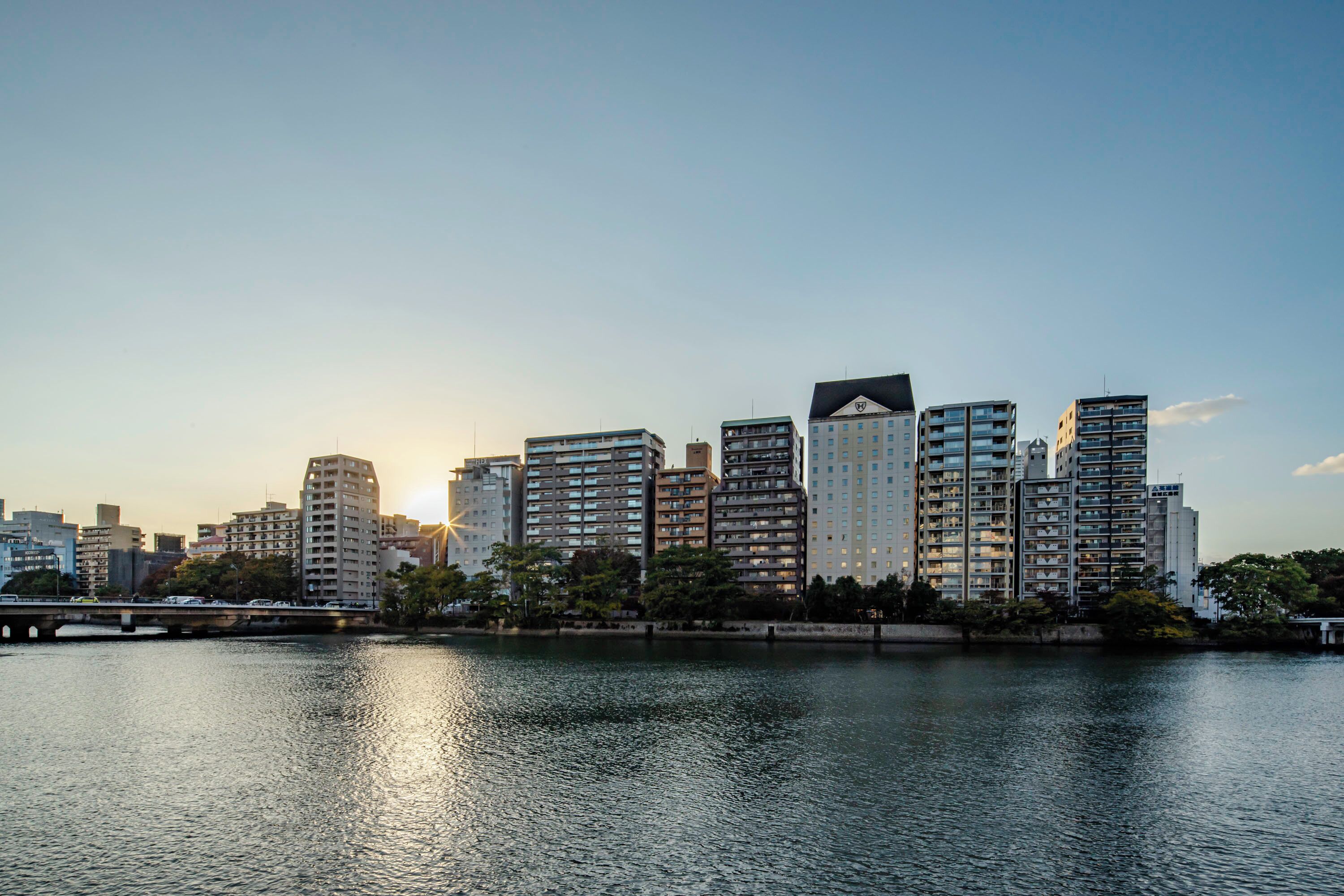 A city skyline with high-rise buildings along a waterfront.