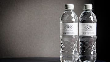 Two clear plastic bottles with labels, placed on a dark surface against a plain background.