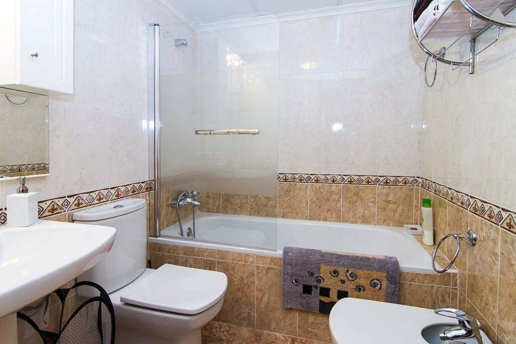 Une salle de bain avec des toilettes, un lavabo et une baignoire.