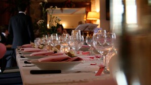 A dining table set with multiple wine glasses, plates, and pink napkins. - Agriturismo Santa Maria (San Venanzo)
