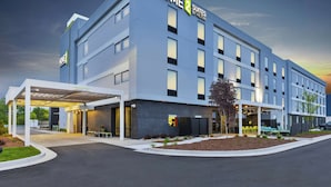 Un hotel moderno con fachada plana, grandes ventanales y un área de entrada techada.