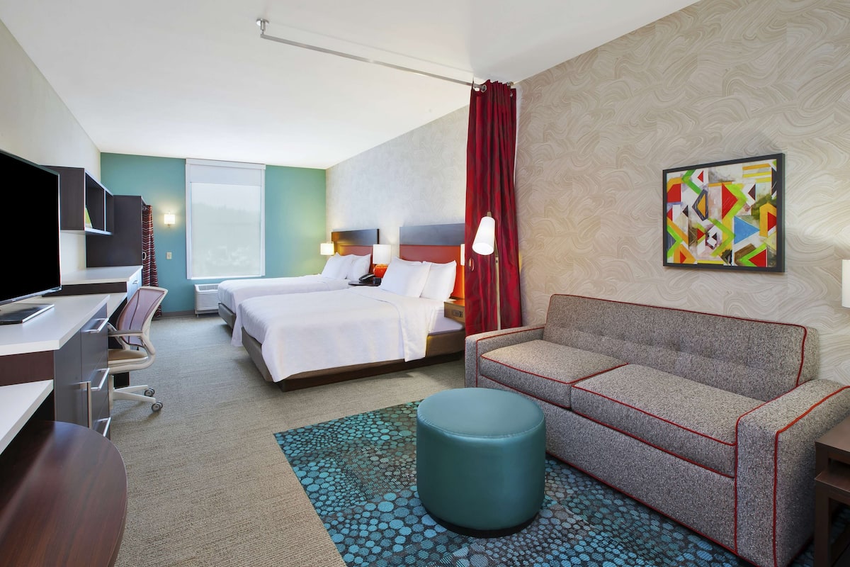Een hotelkamer met een bed, een bank, een bureau en een televisie.
