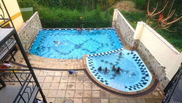 A swimming pool with a checkered edge and a tiled deck area. - Hôtel Le Premier (Kisii)