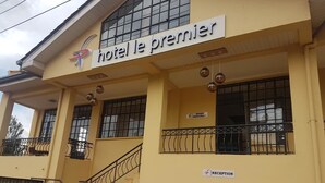 A hotel named "Hotel le premier" with a reception area, a staircase, and a restaurant sign. - Hôtel Le Premier (Kisii)