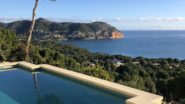 A clear view of a swimming pool with a mountain and sea in the background. - Dream location in Costa Canyamel (Canyamel)