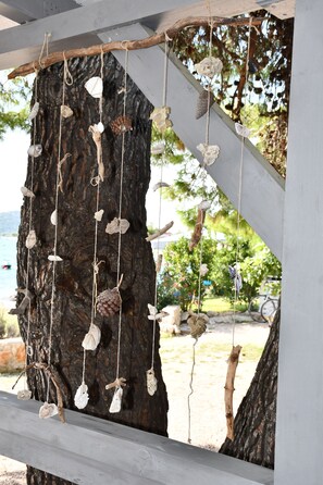 A tree with hanging decorations and a wooden structure. - Holiday house / mobile home in the 1. Line seafront, 34 m² + 24 m² terrace (Pirovac)