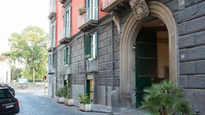 A building with a stone facade, green shutters, and a large arched entrance. - Barbarella Home (Naples)