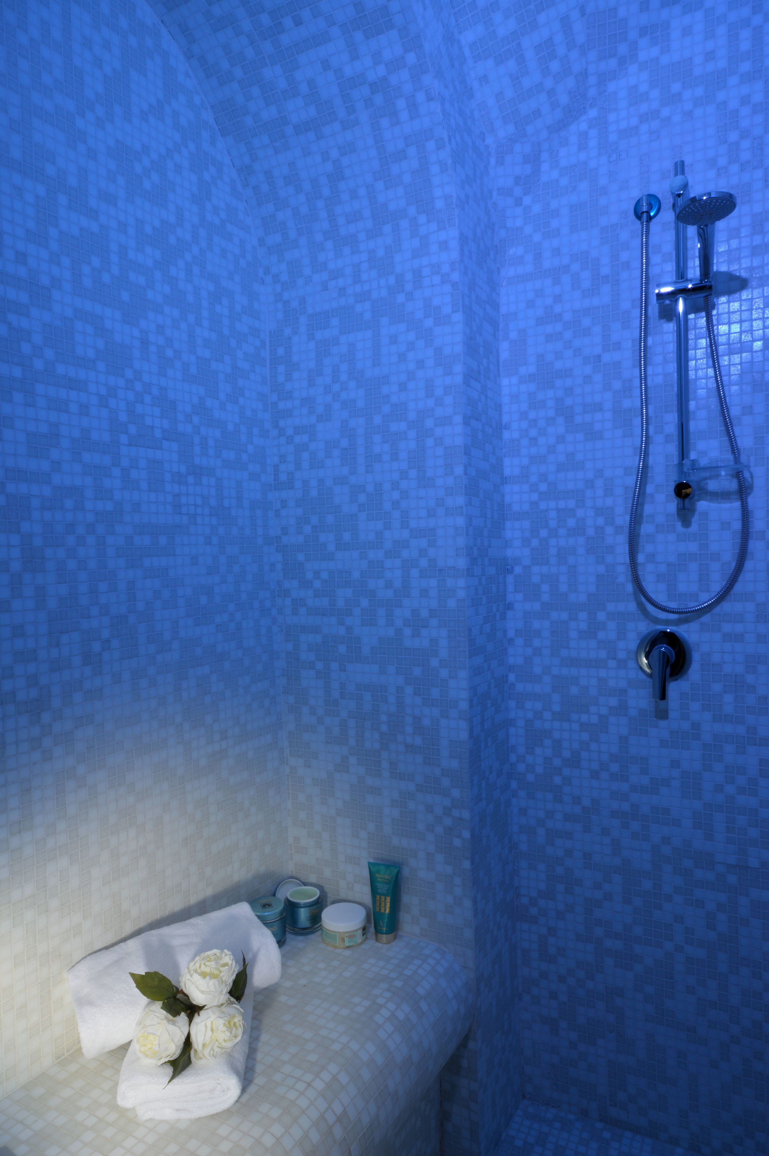A bathroom with a shower, a towel, and toiletries.