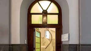 A grand entrance with a wooden door and a glass window above. - Barbarella Home (Naples)