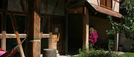 A traditional half-timbered house with a stone foundation, wooden beams, and a tiled roof.
