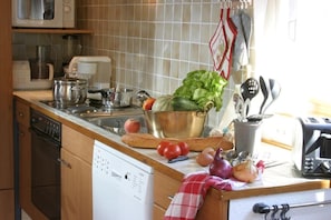 Una cucina accessoriata con lavastoviglie, microonde, tostapane e diversi utensili da cucina.