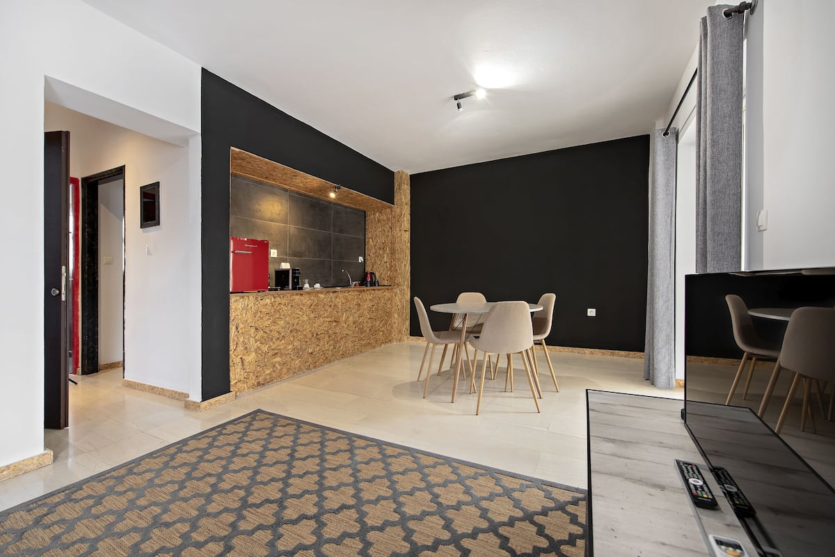 A modern interior with a kitchen area, dining table, and chairs.