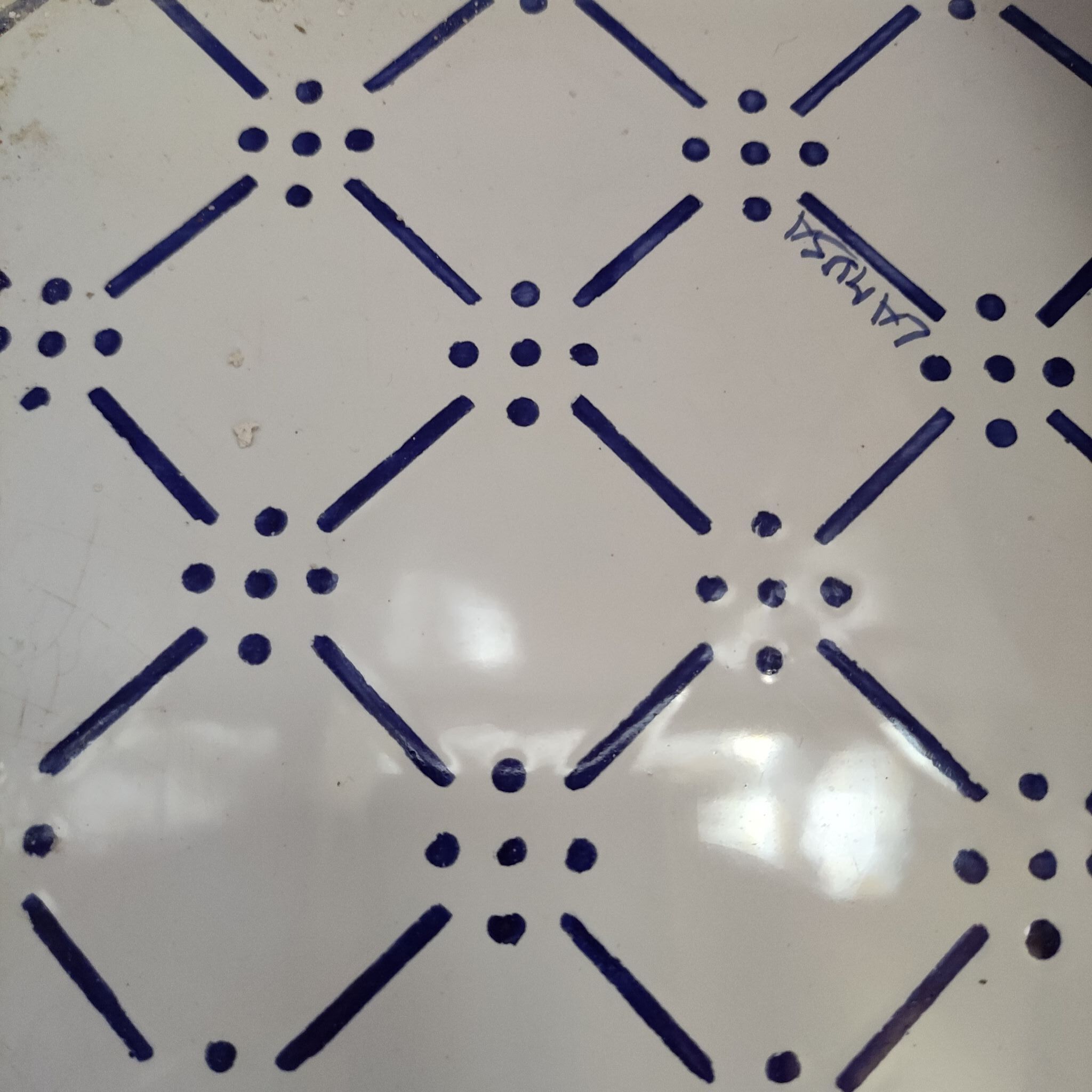 A tiled floor with a geometric pattern of lines and dots.
